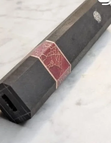 Manche en bois sombre avec insert rouge et détail circulaire